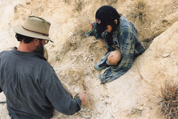 Chuck and a fossil hunt participant dig on a specimen